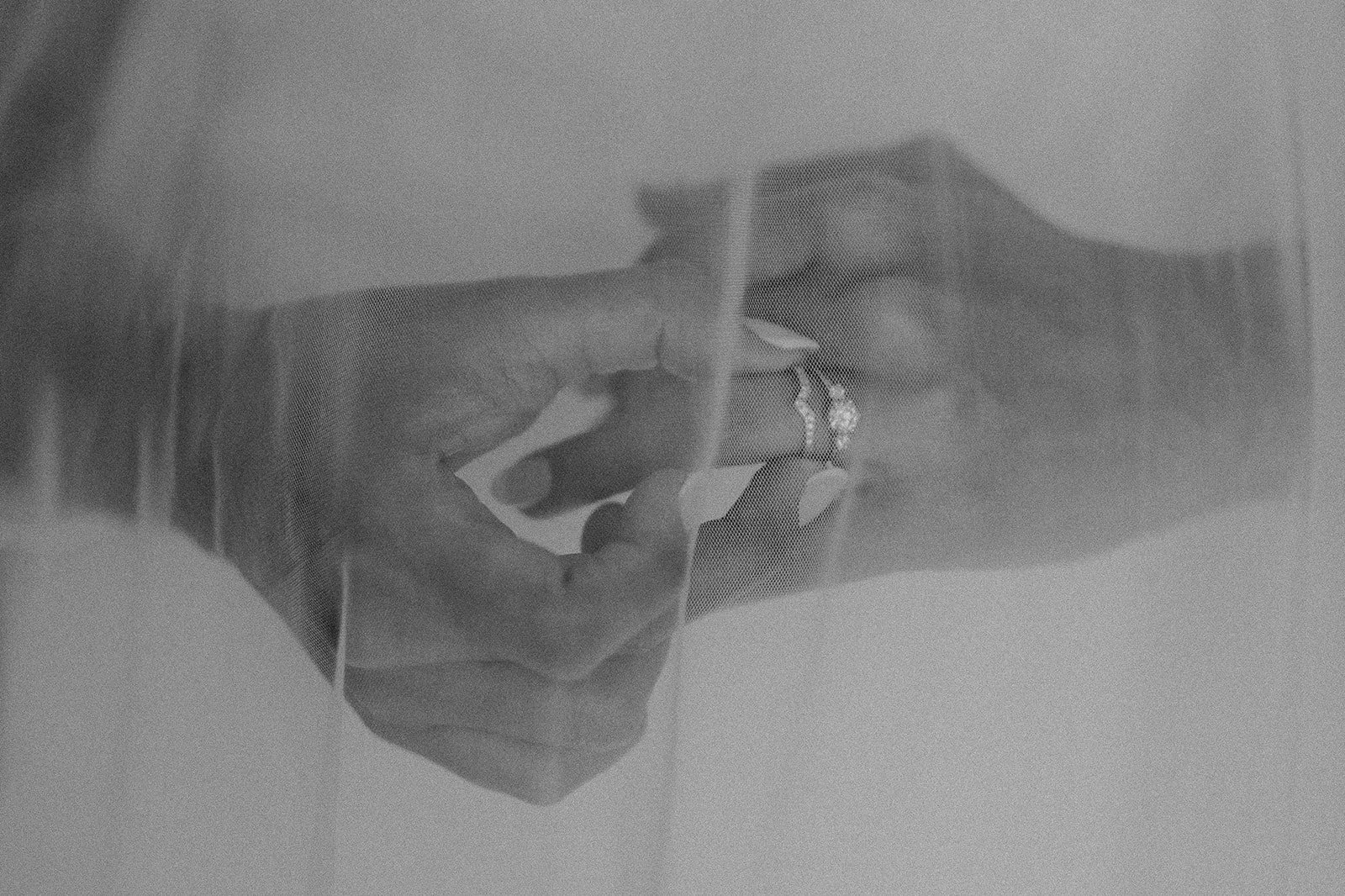 Una mano sostiene un cigarrillo cerca de los labios, visible a través de una malla de protección en una superficie plana.