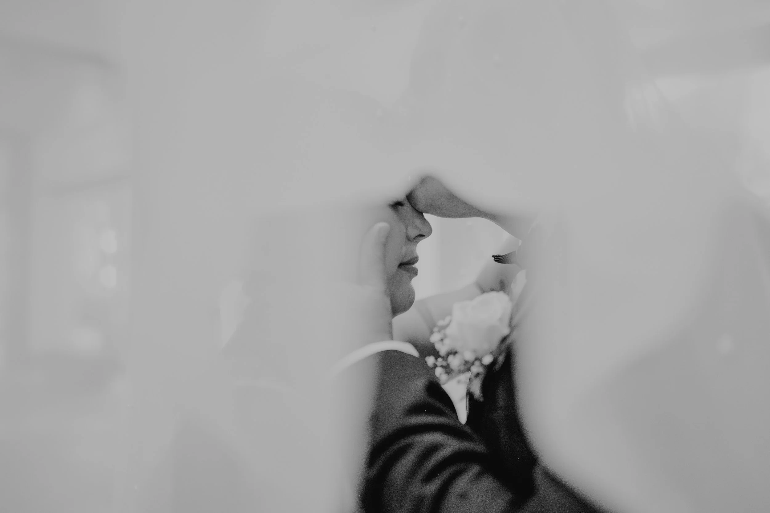 Una persona peinándose o arreglándose frente a un espejo, vista en blanco y negro.