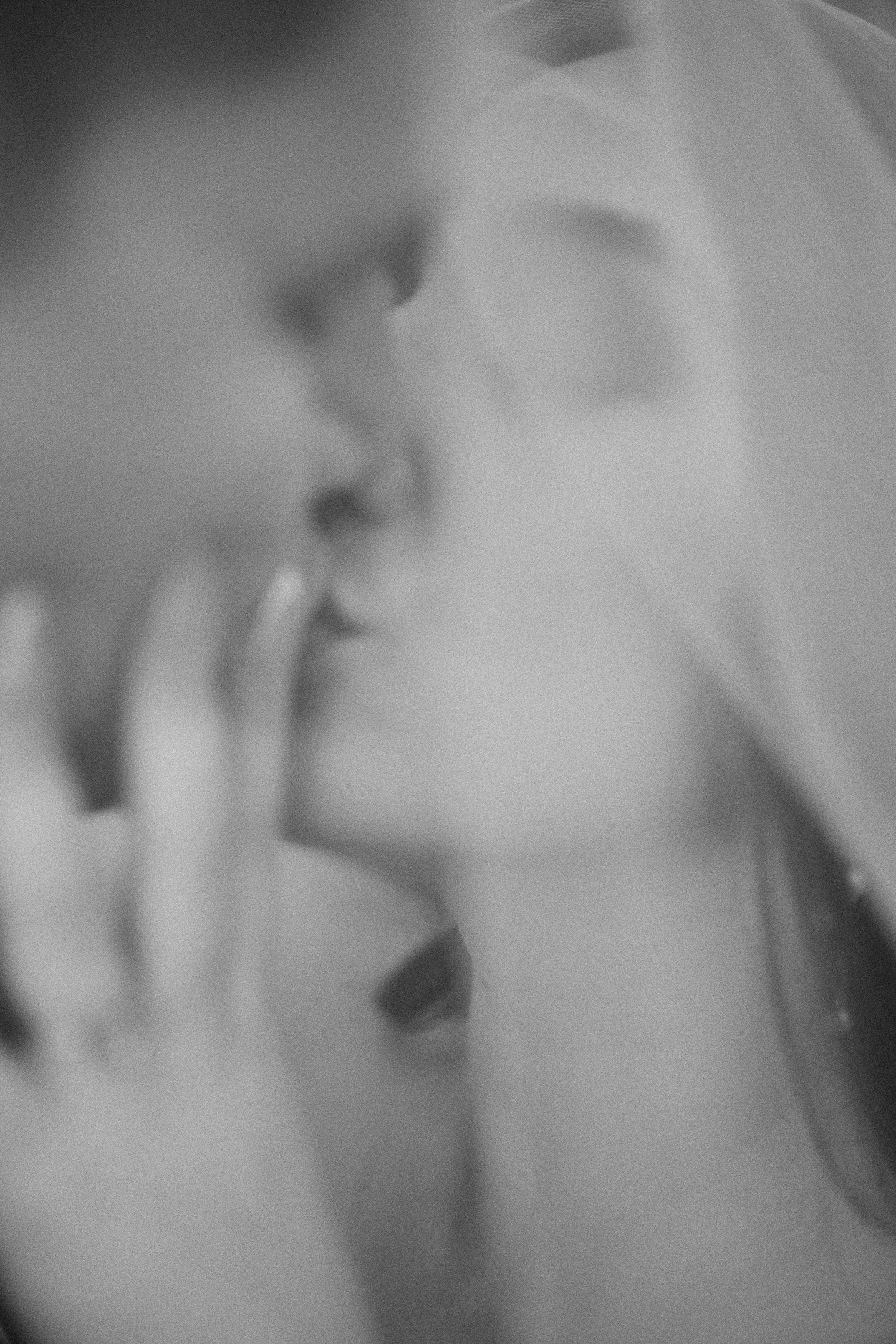 Una pareja besándose con una apariencia borrosa y en tonos grises.