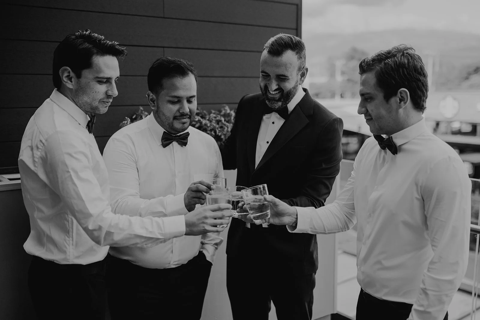 Hombres en traje formal brindando con vasos de agua en una celebración