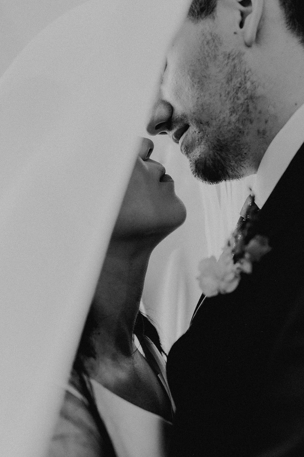 Una pareja en un momento romántico, con los rostros muy cerca, en una fotografía en blanco y negro.