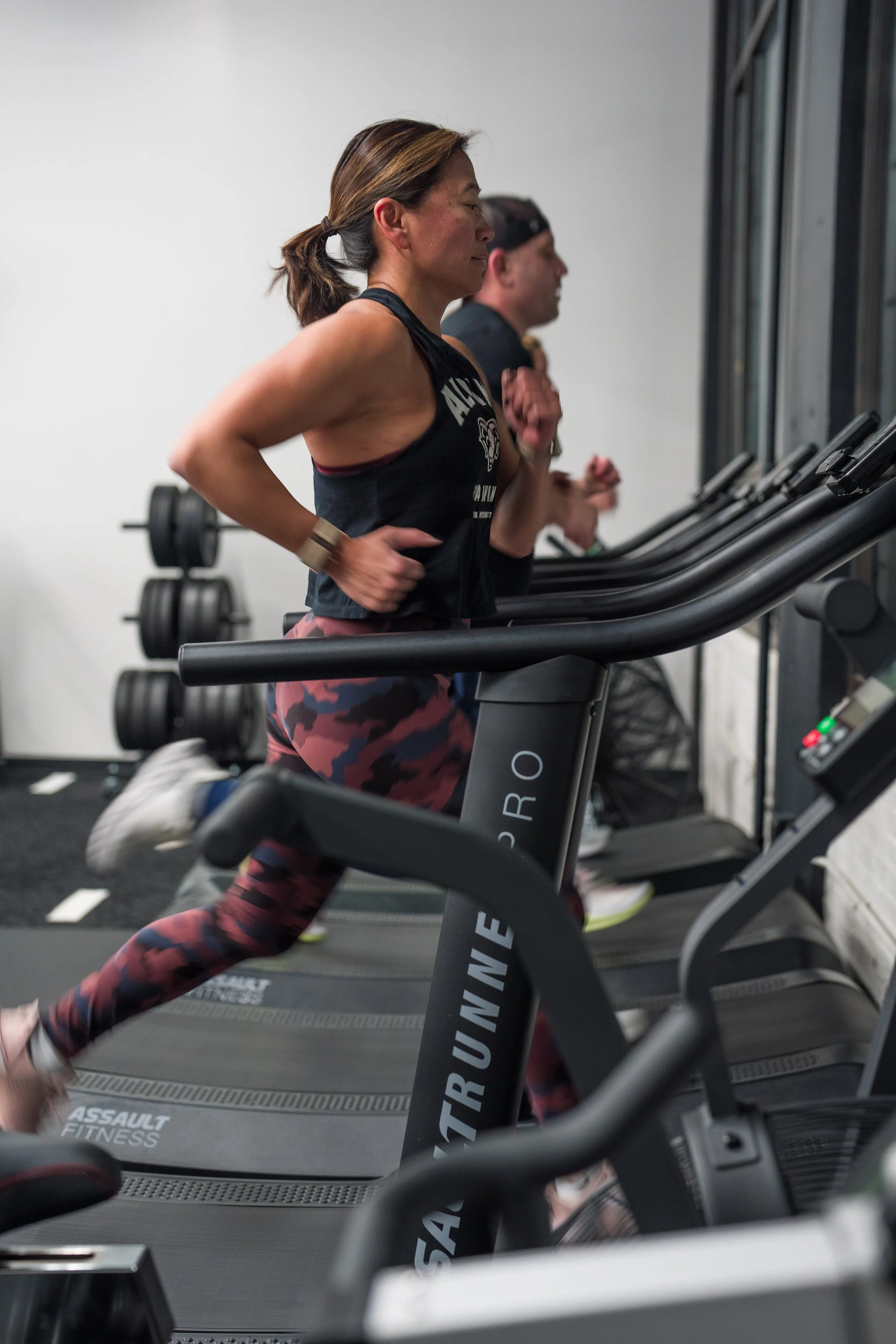 People running on treadmills in a gym.