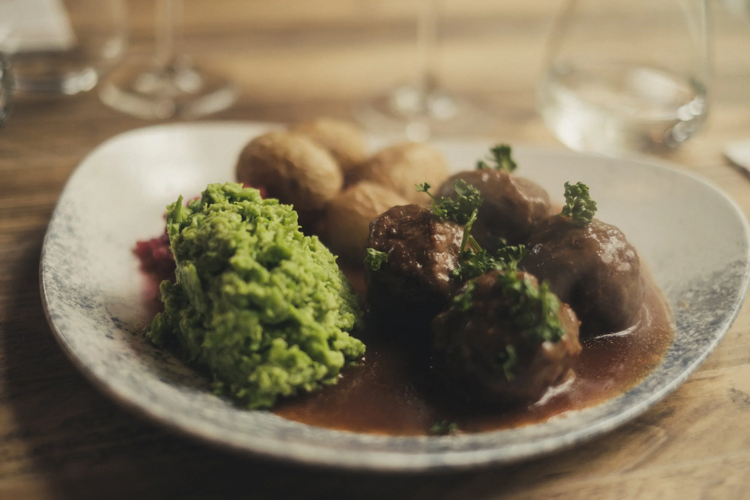 Kjøttkaker i brunsaus med grønn ertepuré og poteter på tallerken - Bygdøy Vertshus