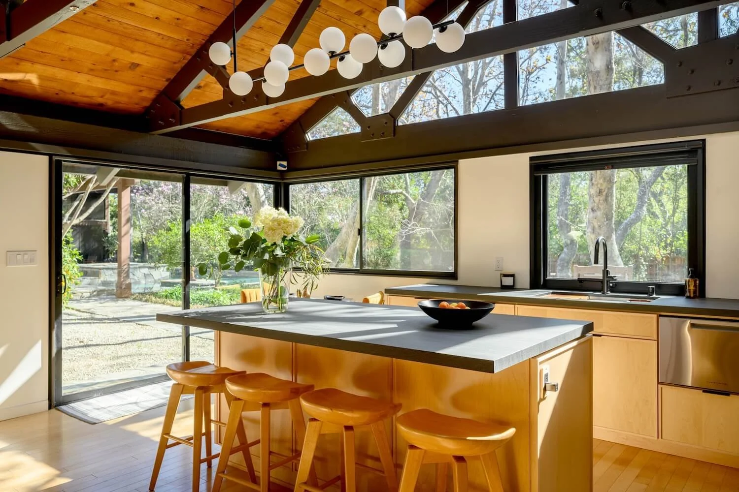 An interior perspective through the kitchen toward the light-filled landscape