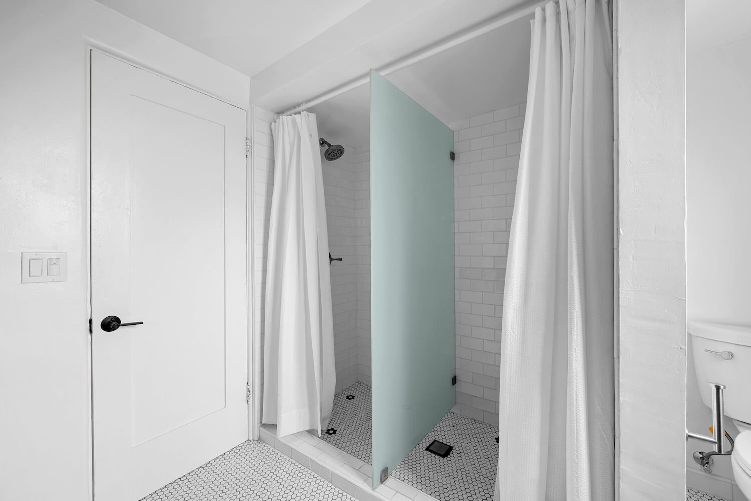 Spatial efficiency: a rebuilt bath featuring a glass divider to create dual shower stalls