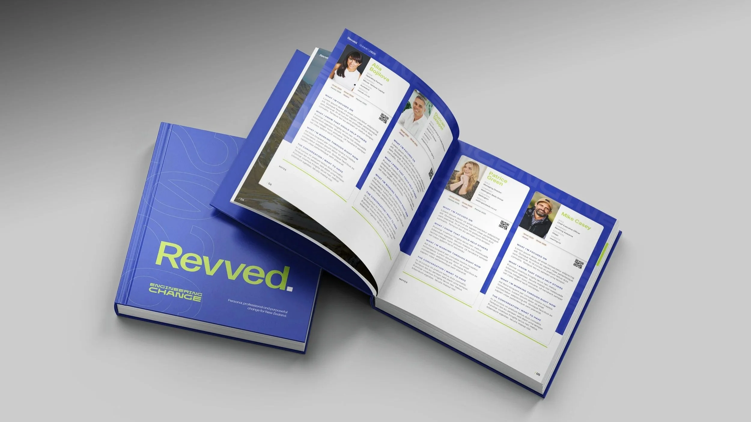 The printed Revved 2026 Drivers Book, closed cover beside an open copy showing one-page leader profiles with headshots and the four questions.