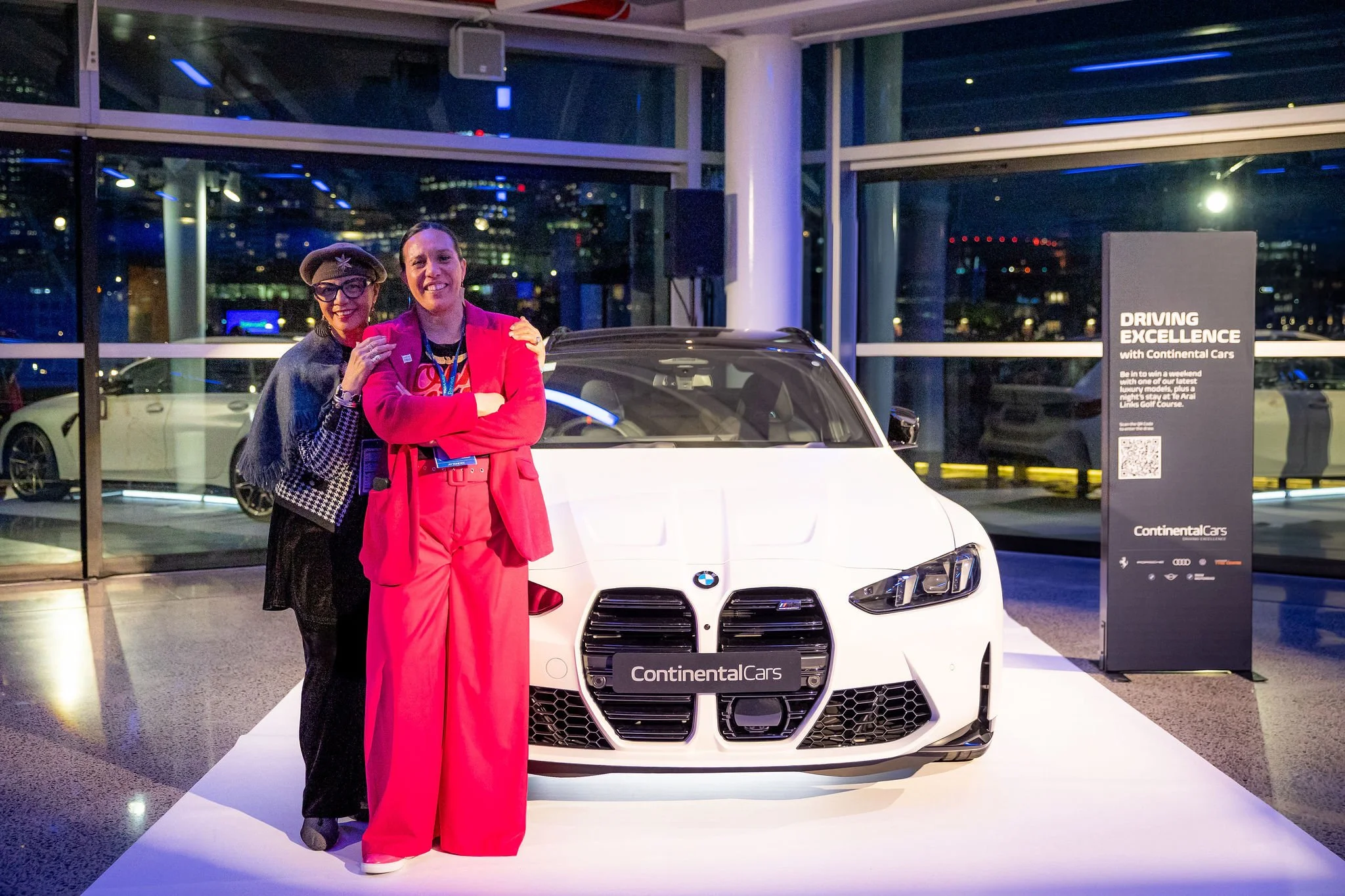 Revved guests in front of a white BMW car at a Revved event