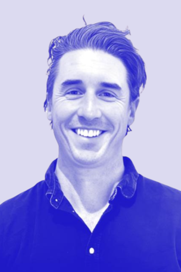 A smiling young man with dark hair and a collared shirt, photographed with a blue-tinted filter against a light background.