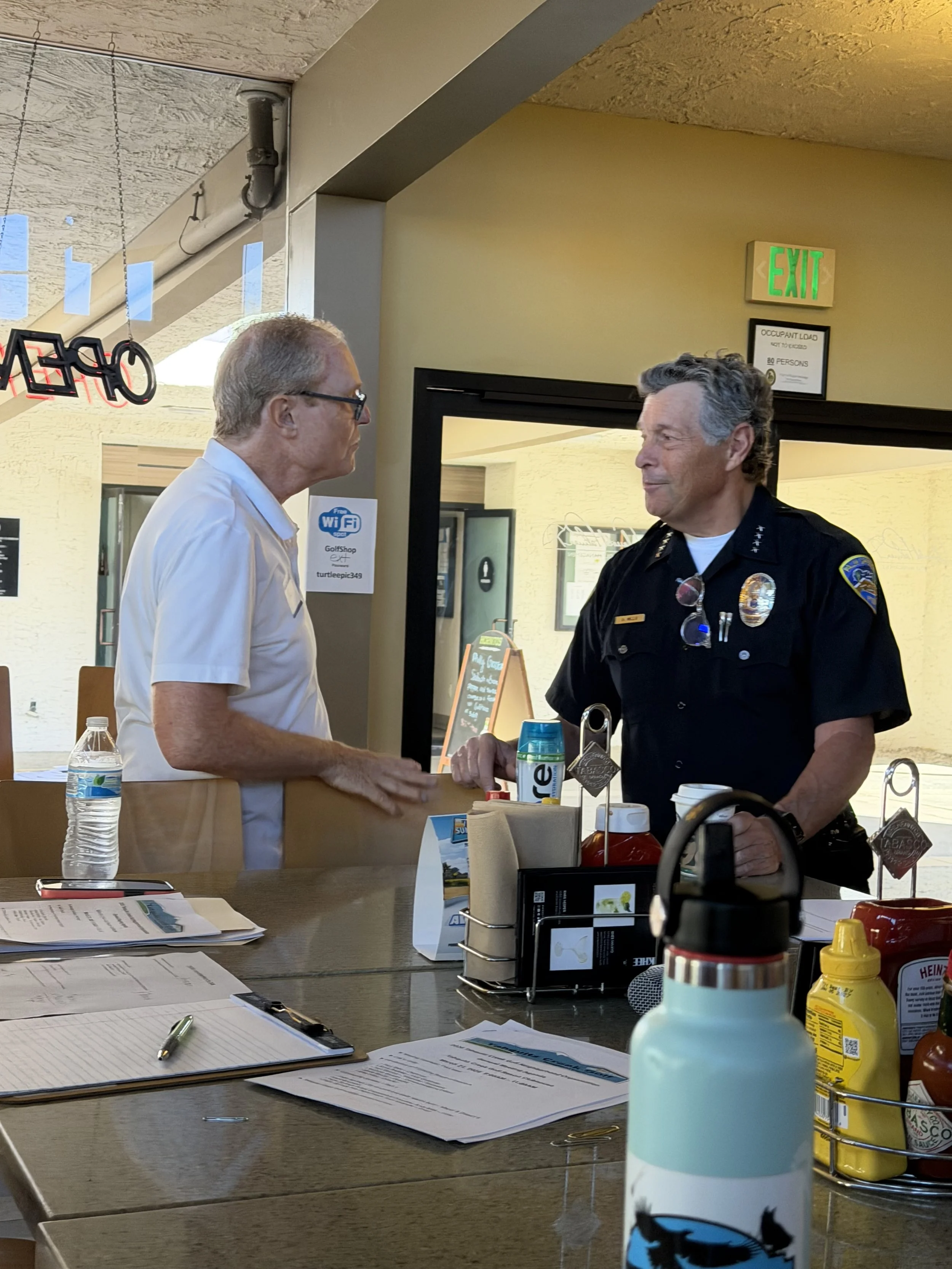 TCGNO Chair speaks with Palm Springs Police Chief Andy Mills at the TCGNO Annual Meeting, held at Tahquitz Creek Golf Course on March 21, 2026.
