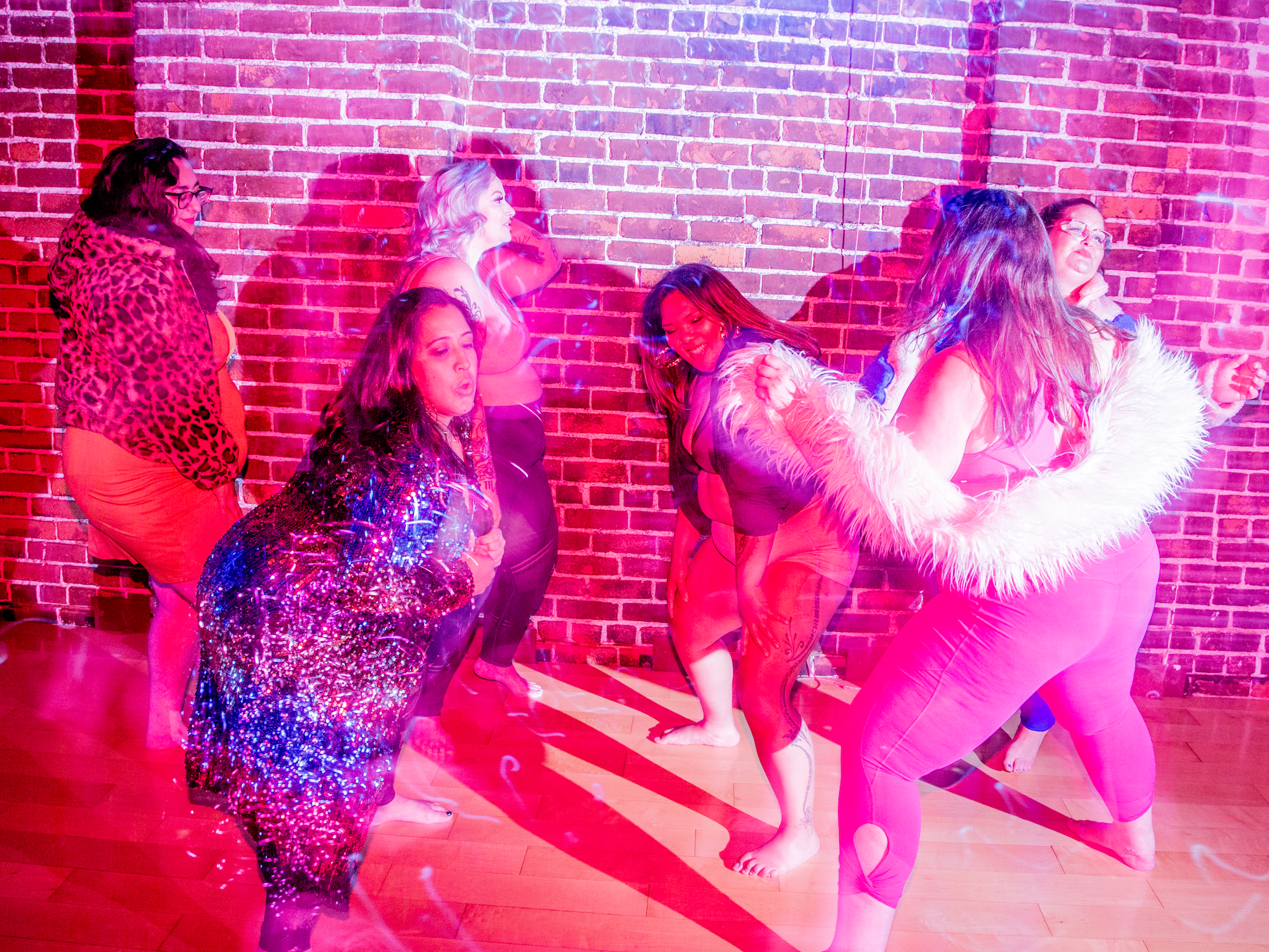 group of plus size dancers by a brick wall dance and party