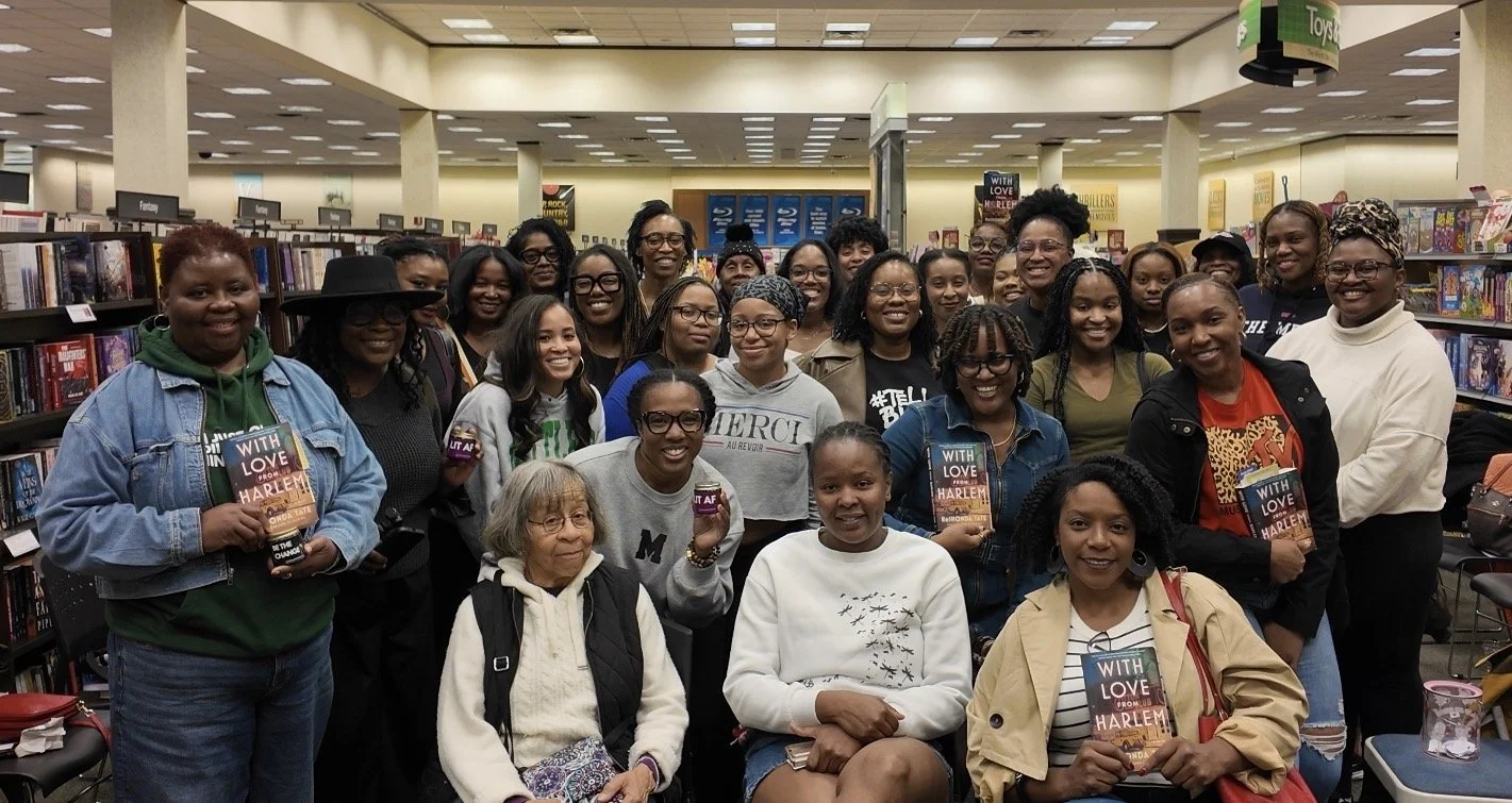 Black Lit. book club members gathered in a bookstore, holding copies of a book titled 'With Love from Harlem'.