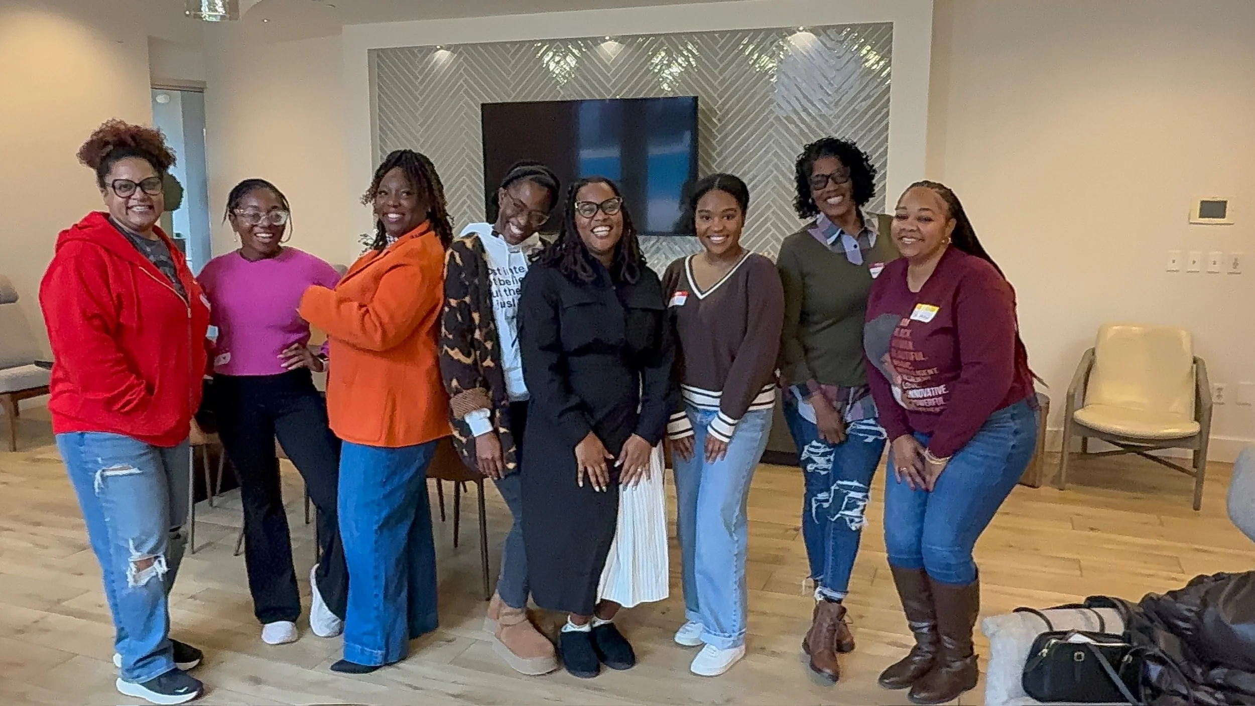Black Lit. book club members standing together indoors, smiling at the camera.