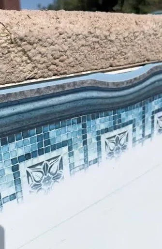 Close-up of a swimming pool liner that is faded and out of the track.