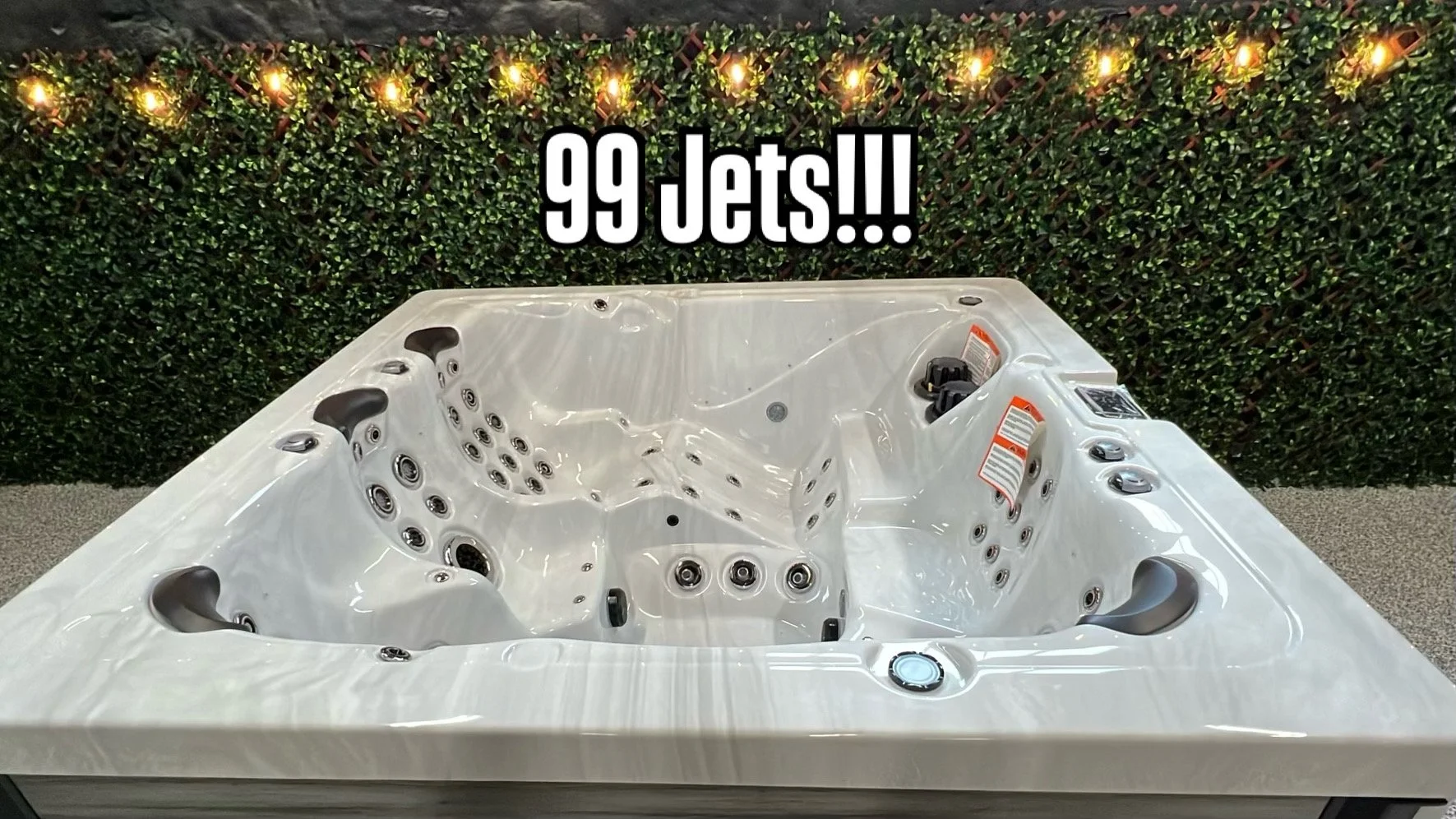 A large white hot tub with 99 jets, control panel, and seating. The text overlay reads "99 Jets!!!".