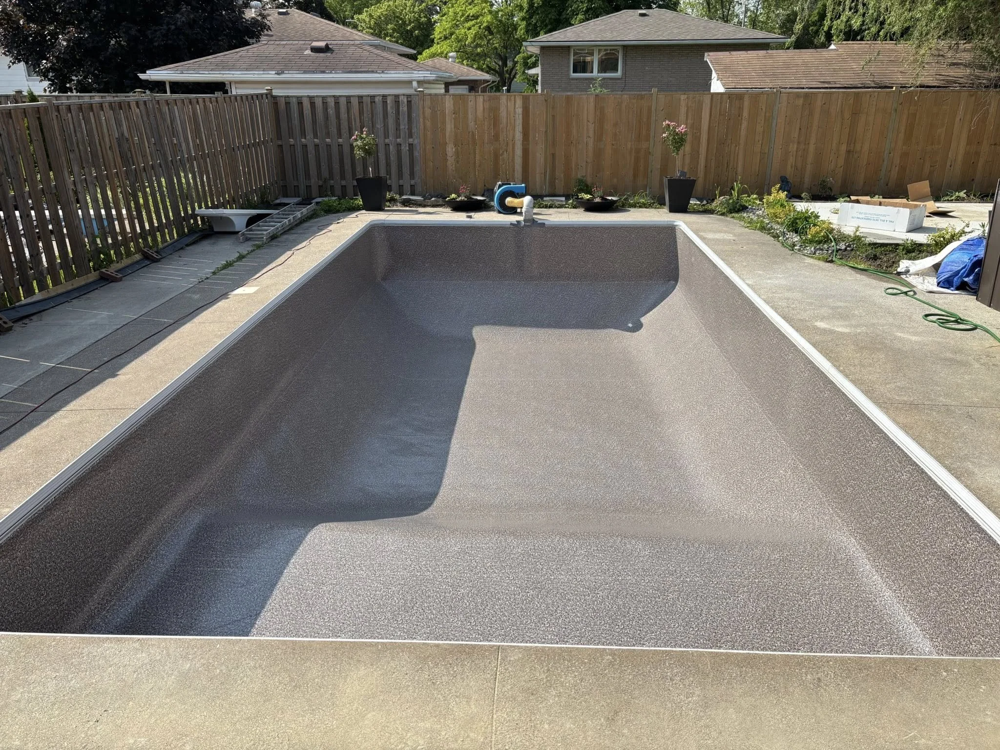 An empty backyard swimming pool that has just had a new liner installed.
