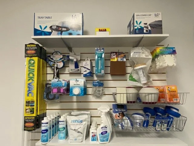 Organized wall shelf with hot tub accessories, cleaning supplies, and storage containers, at hot tub store in Windsor, On.
