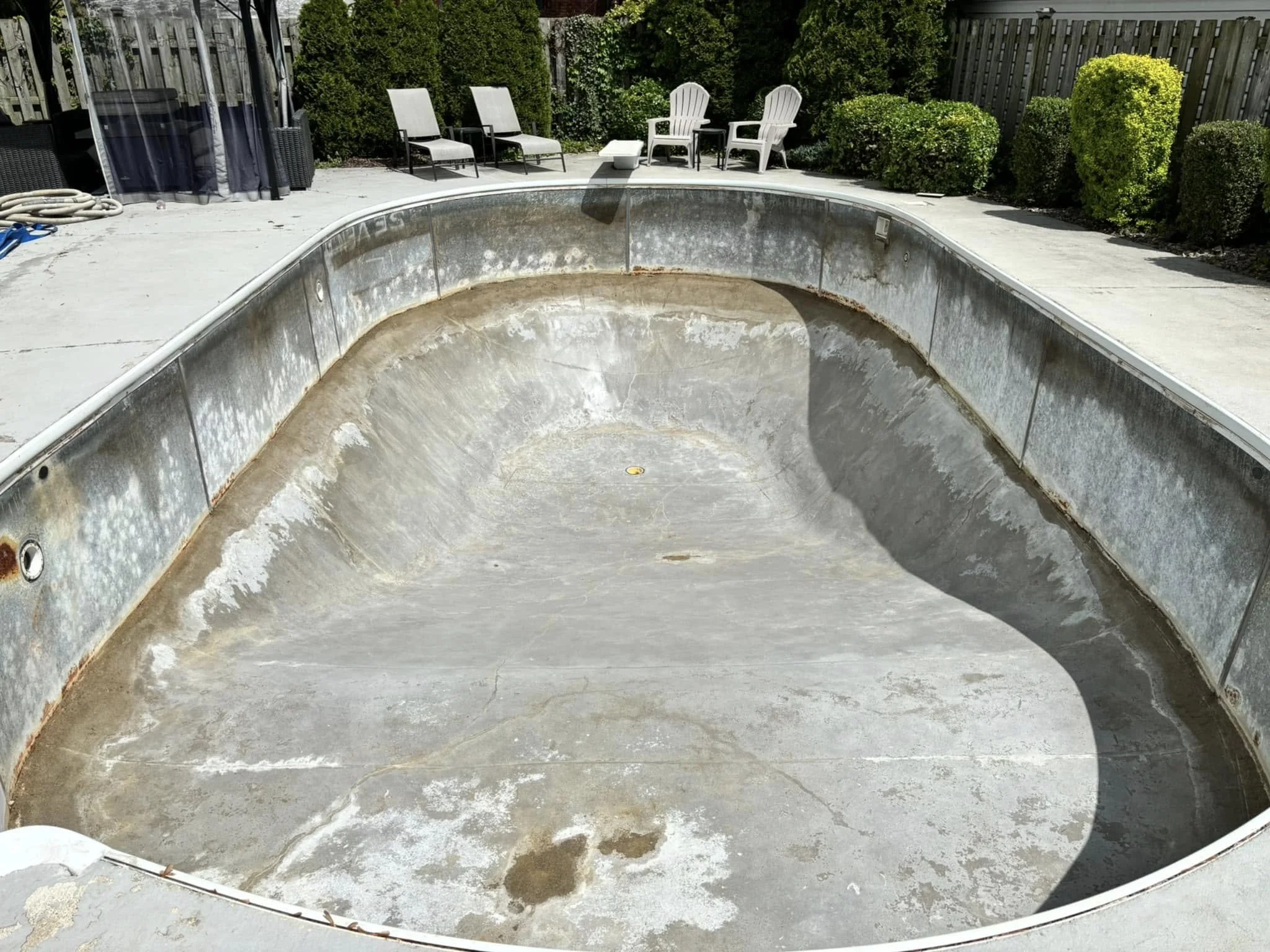 Empty, inground swimming pool that has been prepped for a liner replacement.