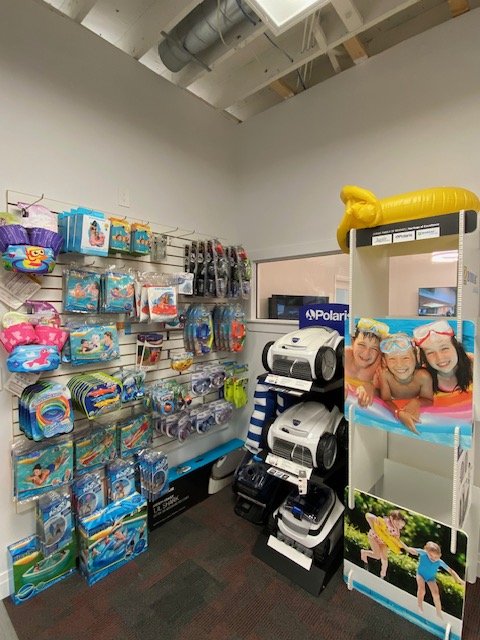 A store display with pool toys, floaties, and accessories on the left, and pool cleaning robots on the right.