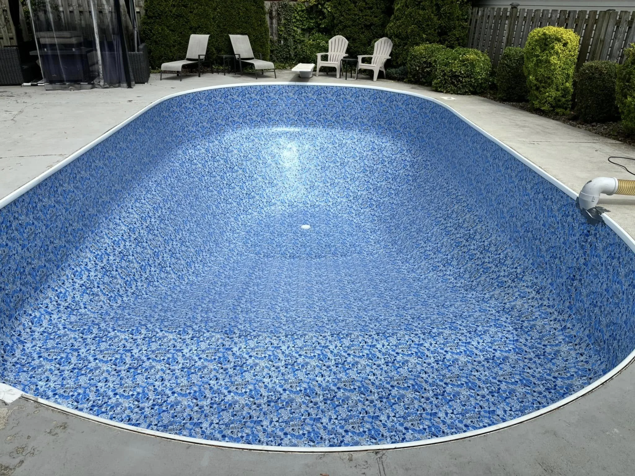Empty inground swimming pool after liner replacement.