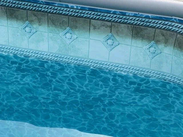 Close-up of a swimming pool's edge showing a faded liner.