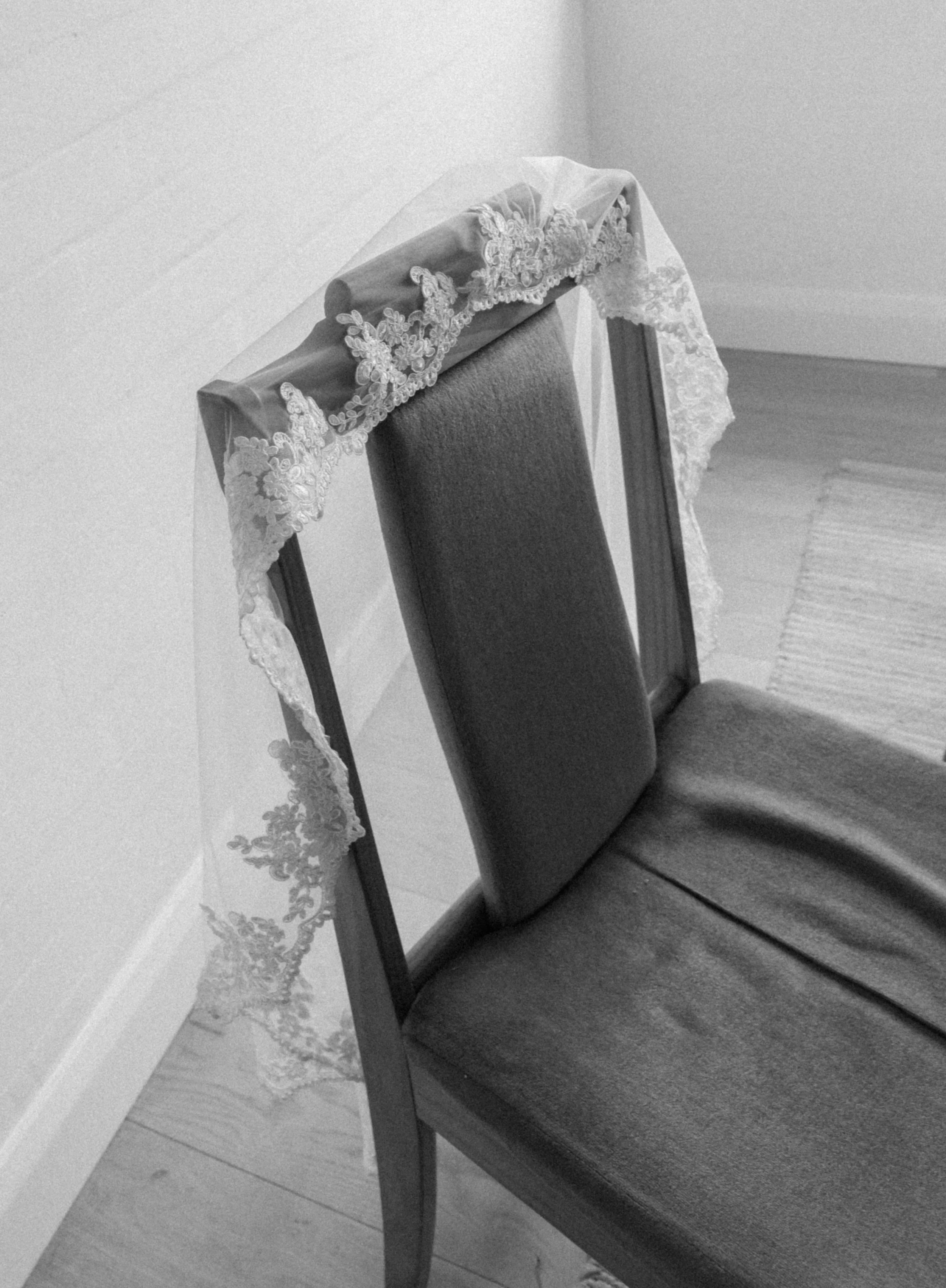 Wedding veil laying on chair in black and white