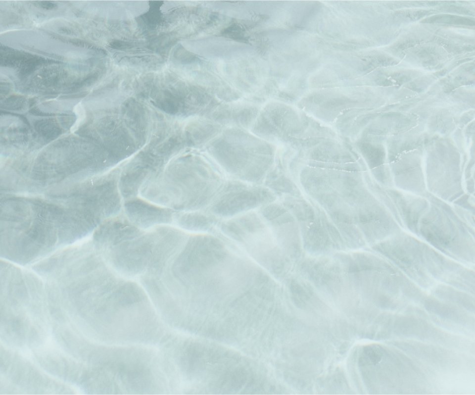 Close-up of clear ocean water with sunlight reflecting on the surface.