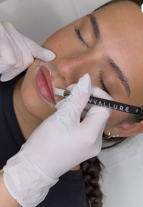 PMU artist performing lip blush cosmetic tattoo treatment
