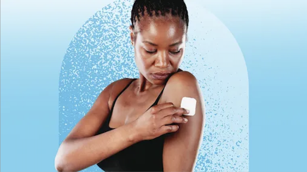 A woman attaches a glucose monitor to her arm.