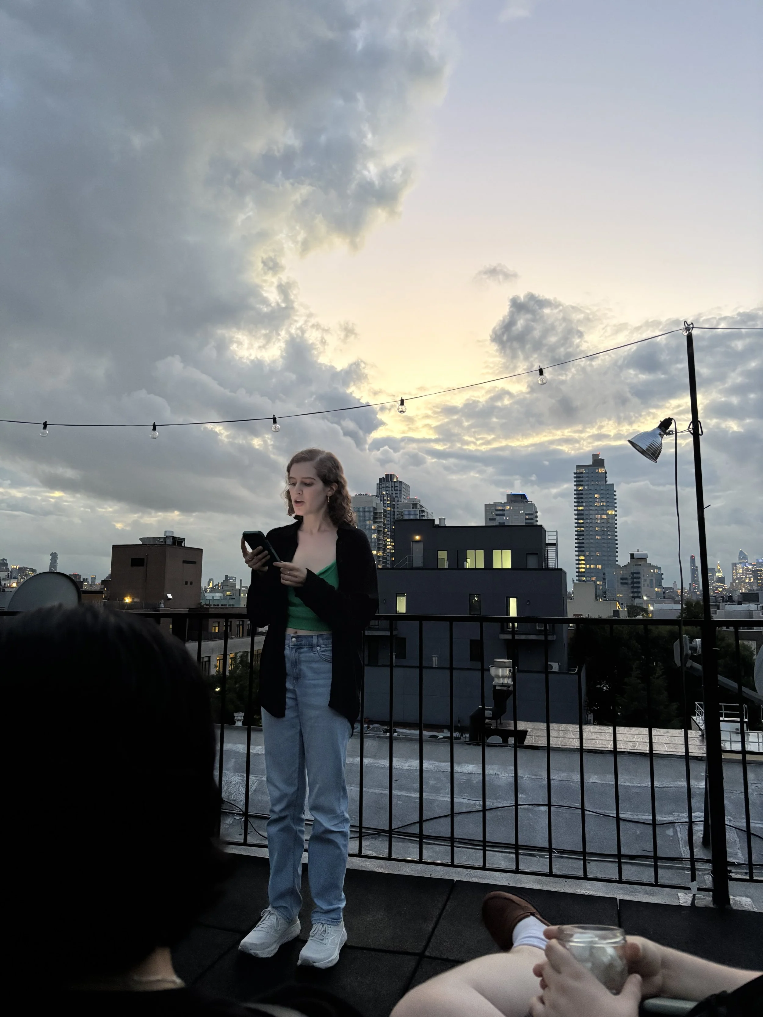 Jacqueline reads on a roof at sunset. 