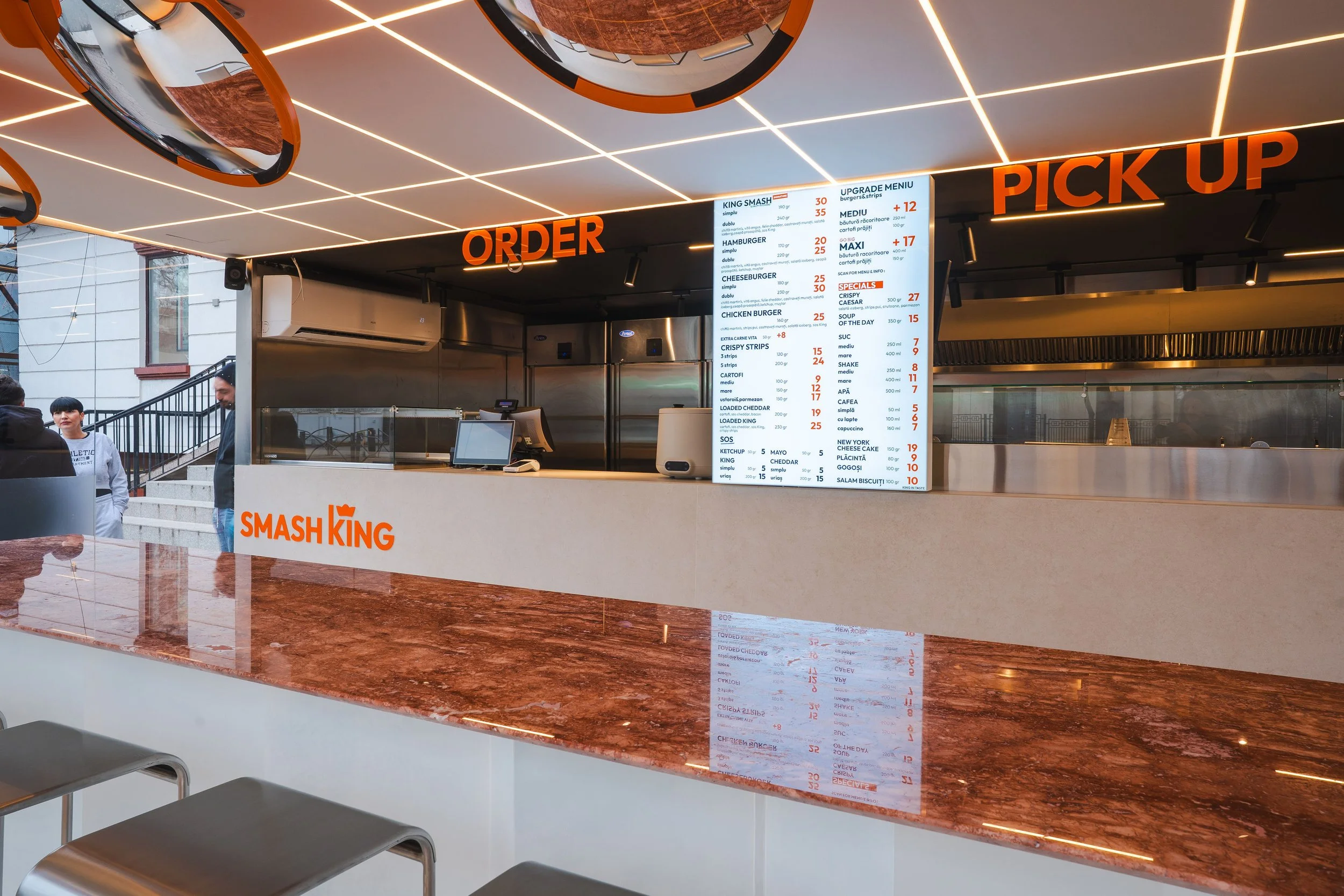 Design interior restaurant fast-food cu identitate vizuală puternică și elemente grafice integrate