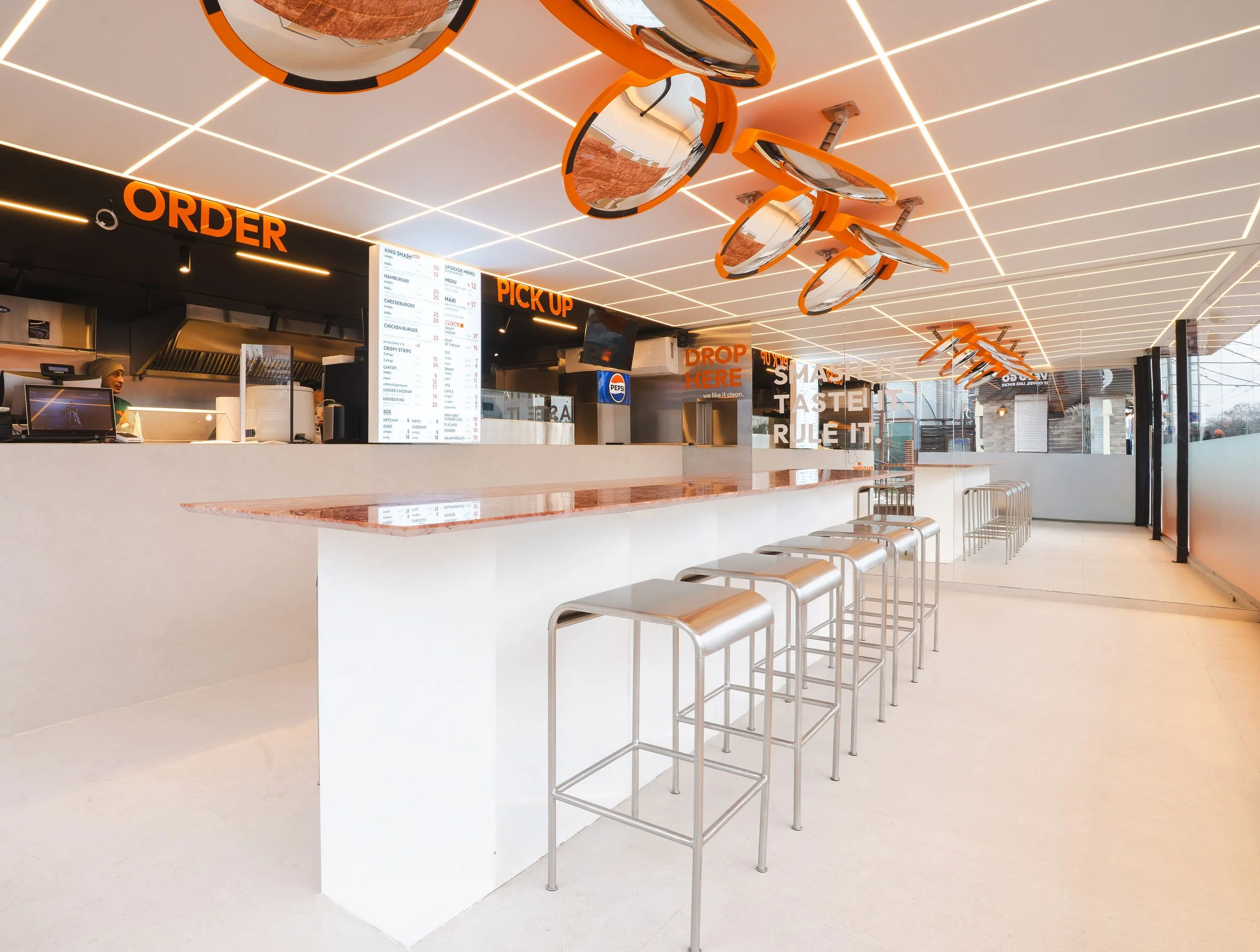 Interior SmashKing cu design fast food modern, masă centrală și zonă de comandă