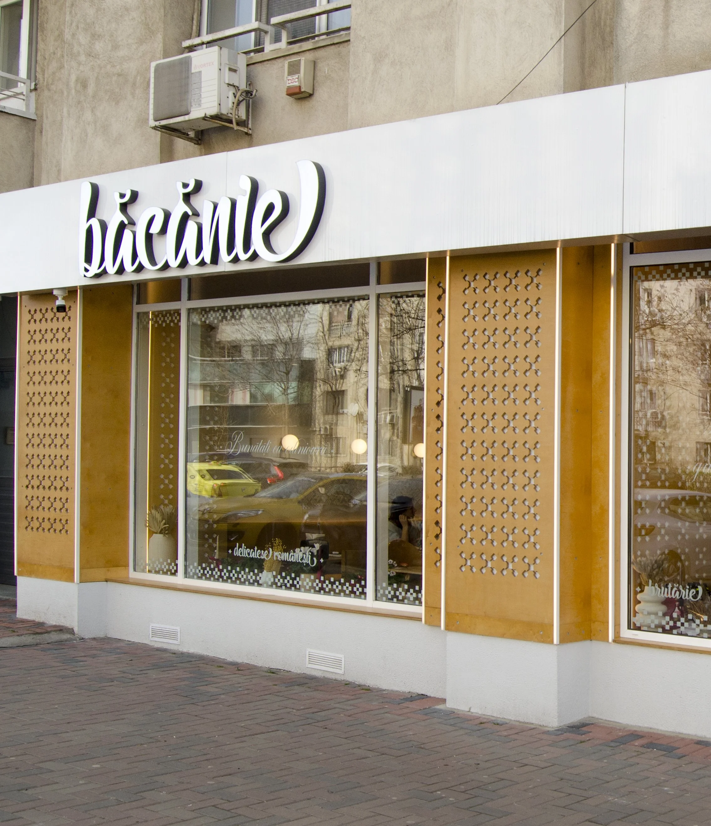 Fațadă spațiu horeca ma.iu cu panouri decorative perforate și vitrină către stradă