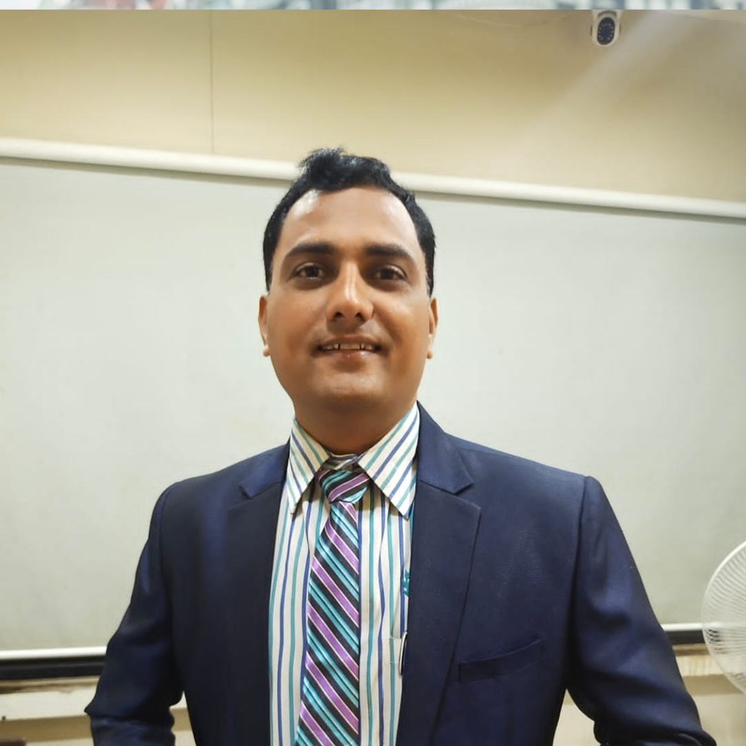 A man in formal attire standing in an indoor setting.