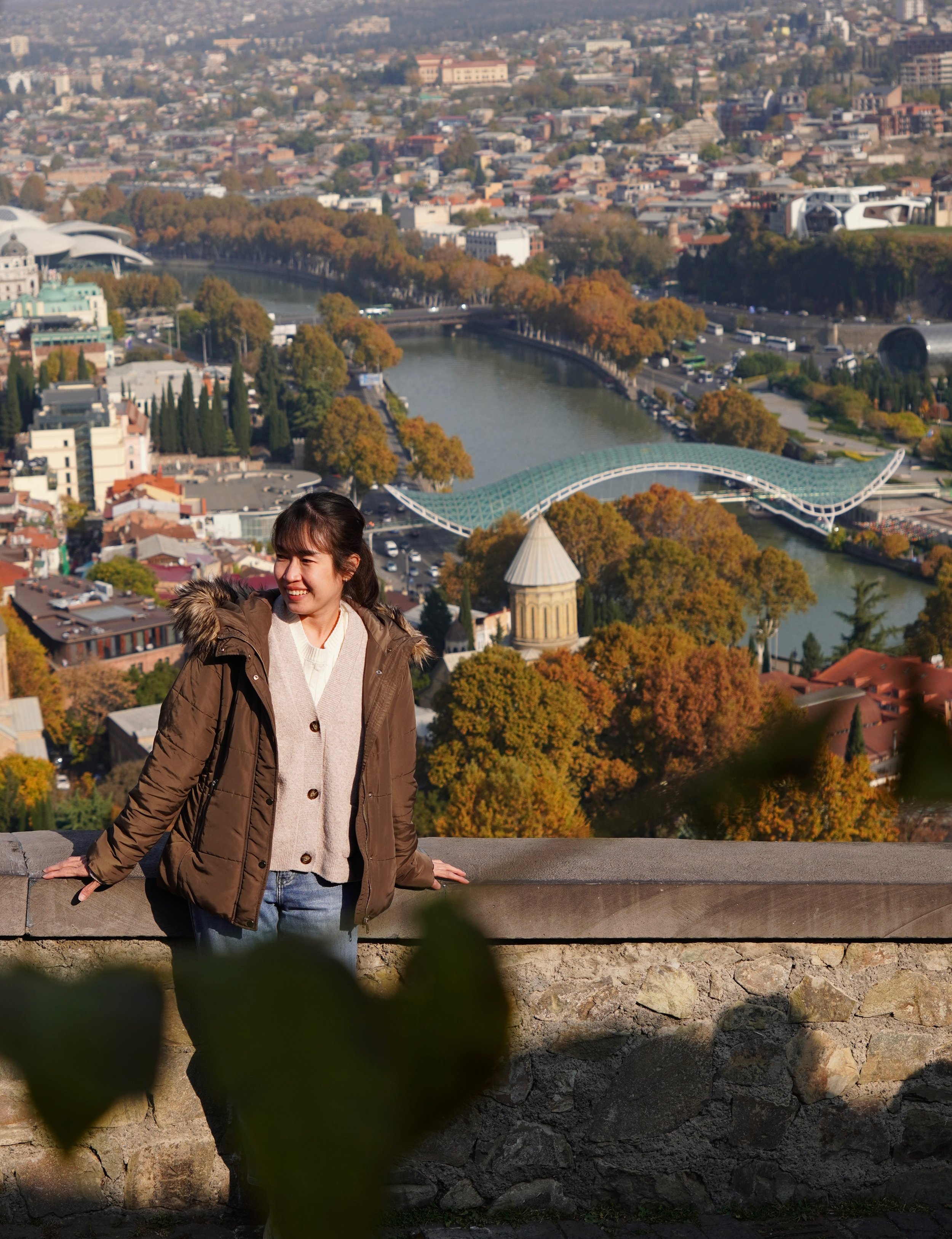 Scenic view of a lake surrounded by green hills and mountains with cloudy sky