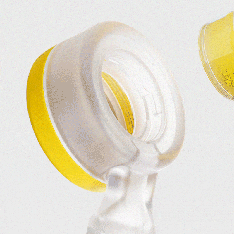 Shower head with water spraying into a yellow and white container, with another yellow container in the background.