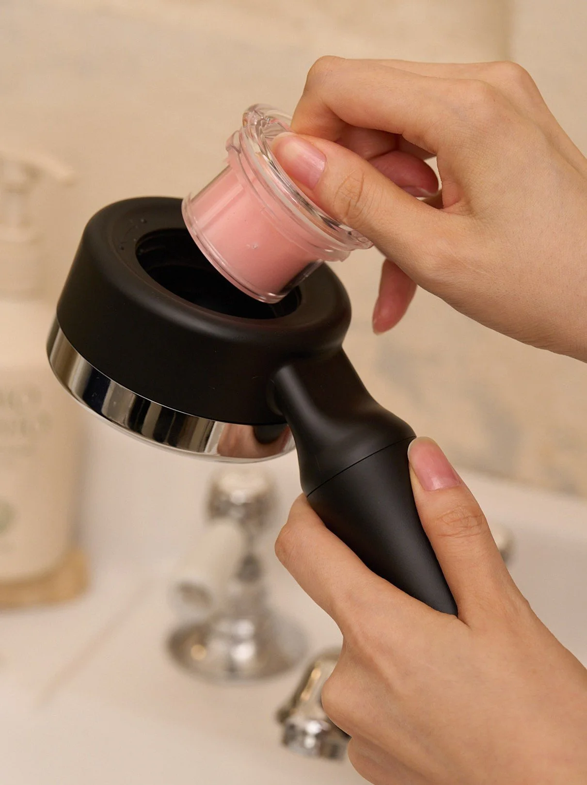 Person holding Waterwel vitamin C shower head in bathroom