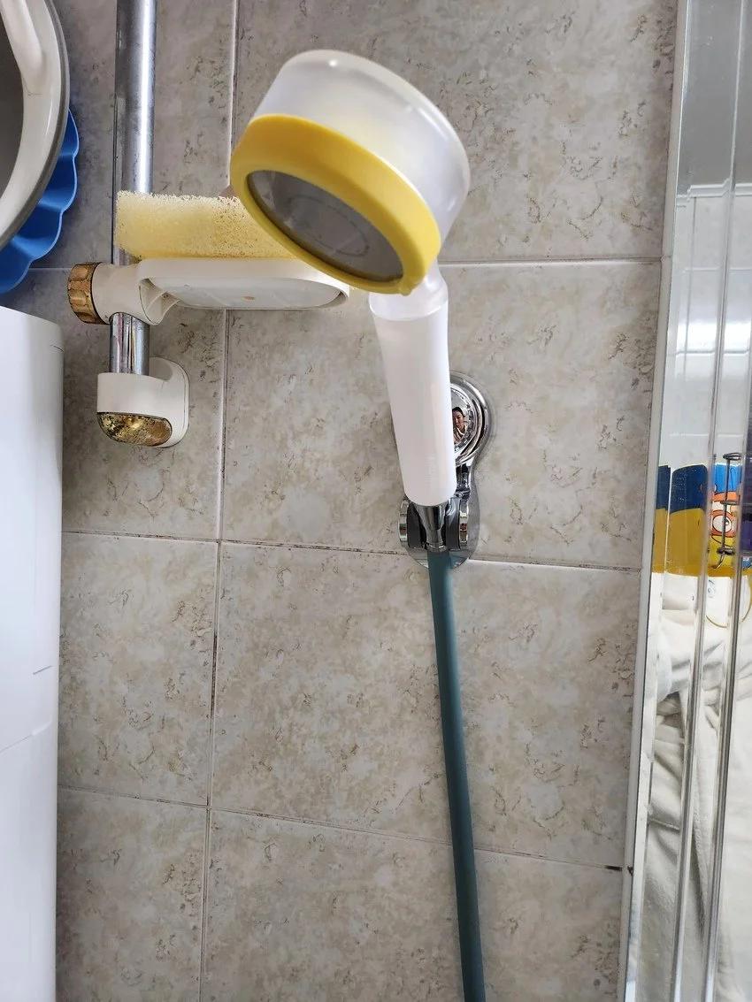 Bathroom wall with mop, sponge, and cleaning supplies.