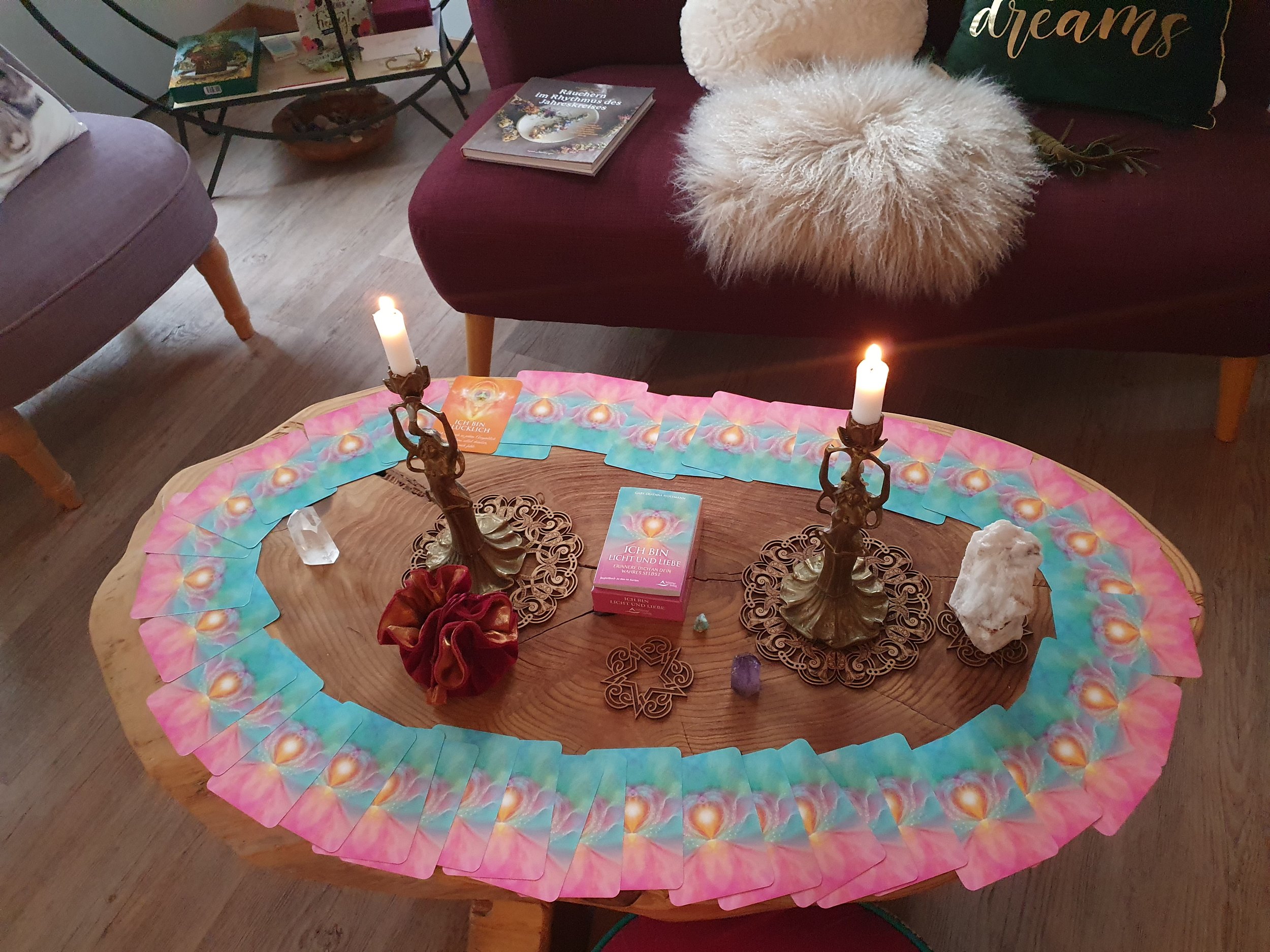 Ritualgegenstände auf einem Tisch, darunter Muscheln, Kristalle, Kerzen, Pflanzen, Tarotkarten und ätherische Öle, für eine spirituelle Praxis