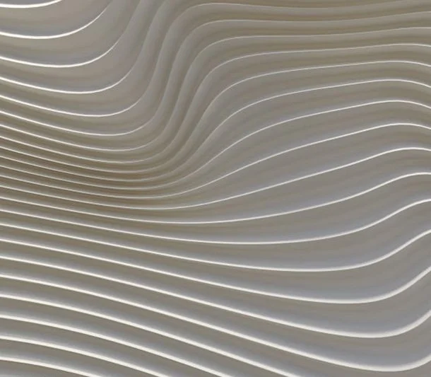 Close-up of silver metallic wavy architectural panels with horizontal ridges.