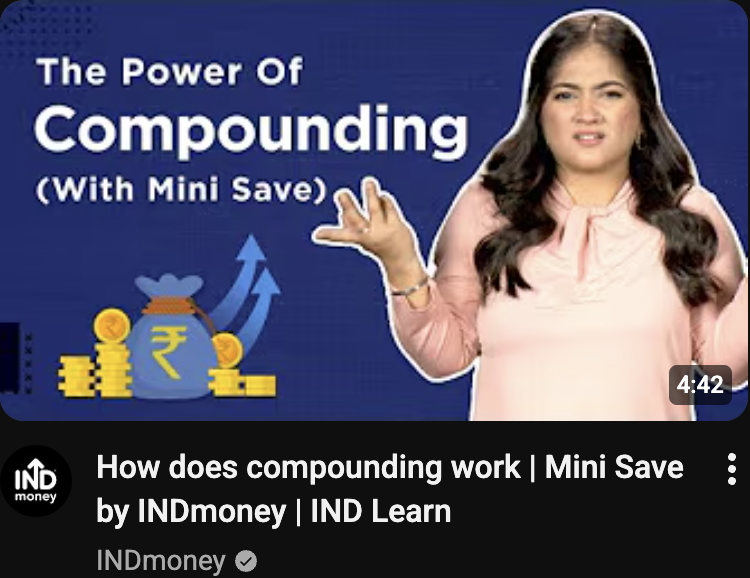Thumbnail for a video titled 'How does compounding work | Mini Save' by INDmoney. The thumbnail features a woman with long dark hair wearing a pink top, gesturing with her left hand. The background is blue with white text that reads 'The Power of Compounding (With Mini Save)' and includes an illustration of a money bag, coins, and upward arrows.