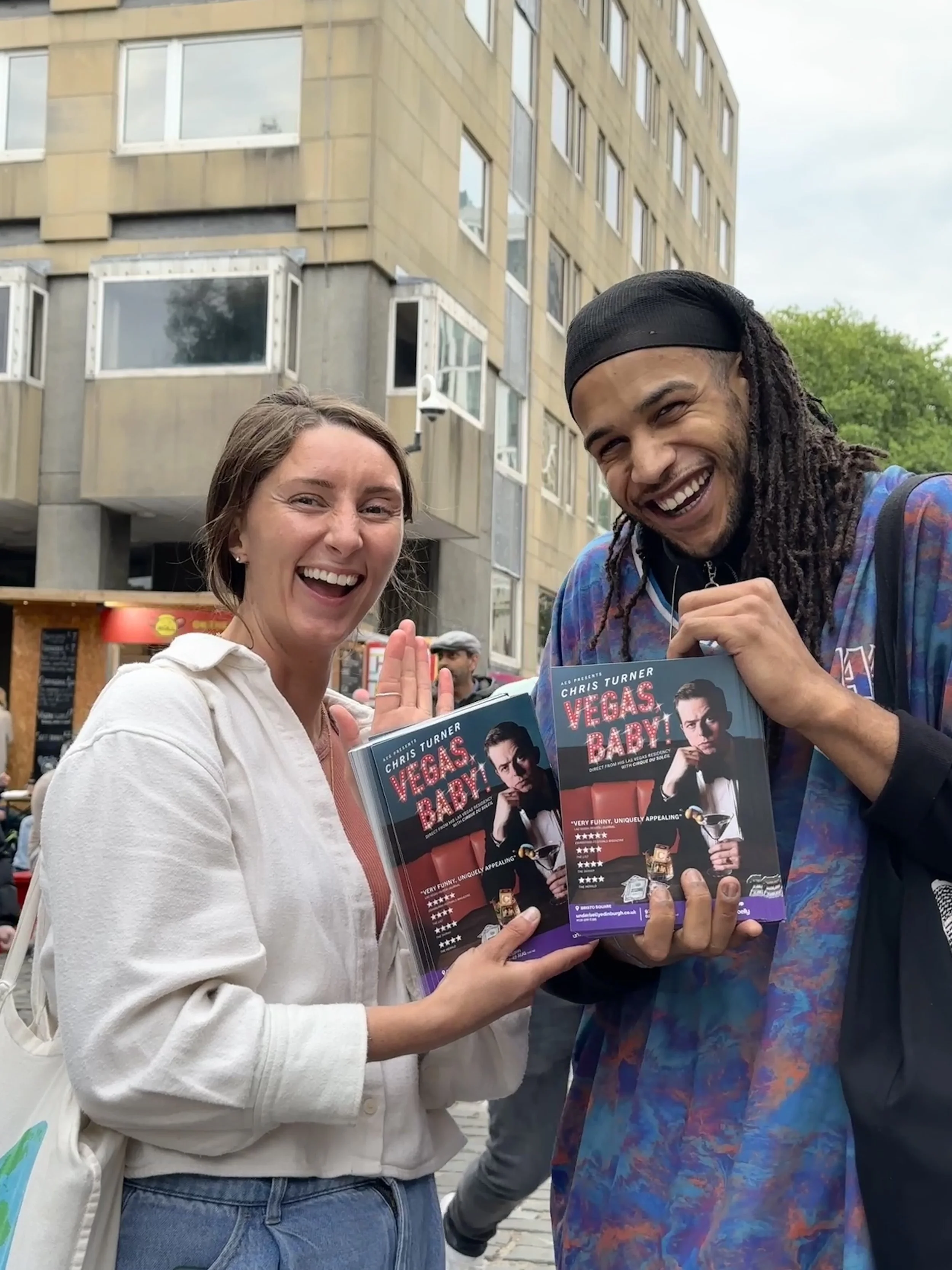 Two happy Flyerers holding up flyers of the play "Vegas Baby!" at the Edinburgh Fringe Festival.