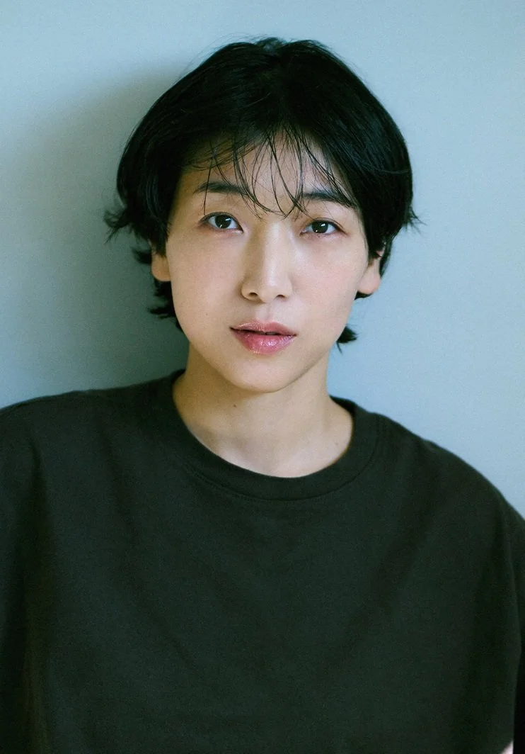 黒いシャツを着た若い男性の正面肖像写真