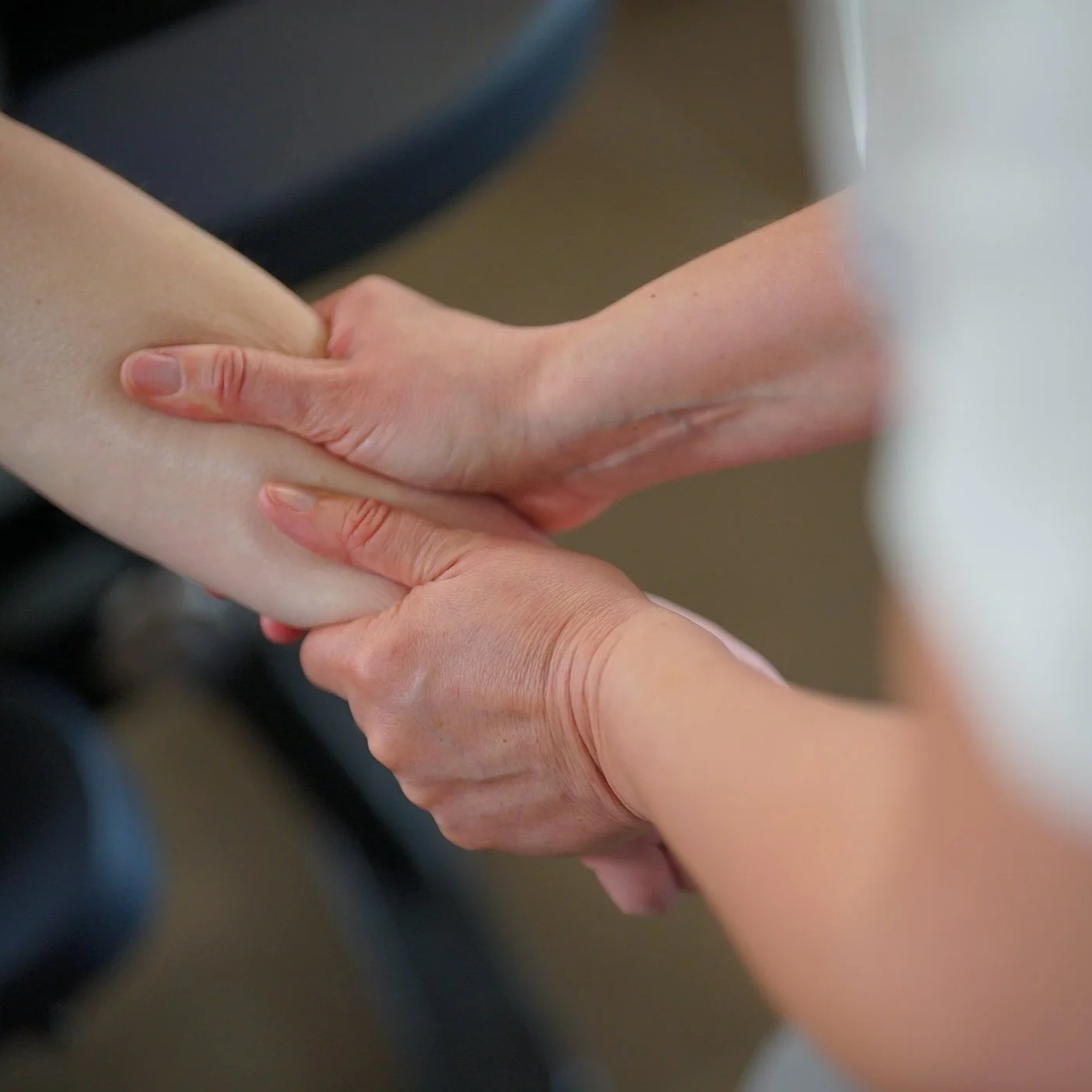 Une personne effectue une manipulation thérapeutique ou un massage sur le bras d'une autre personne.