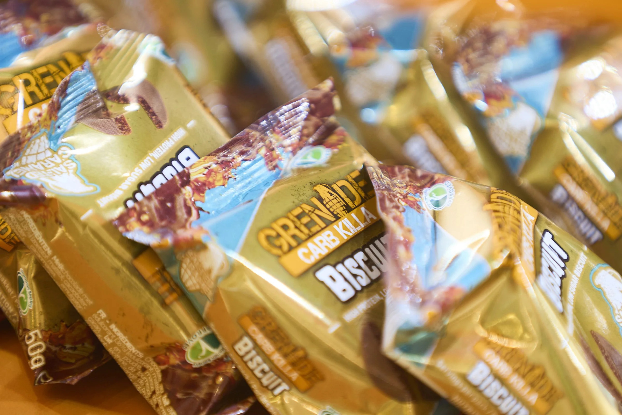 Multiple packages of SnapFrozen brand biscuit cheese snacks with yellow and brown packaging, some featuring blue and green details.