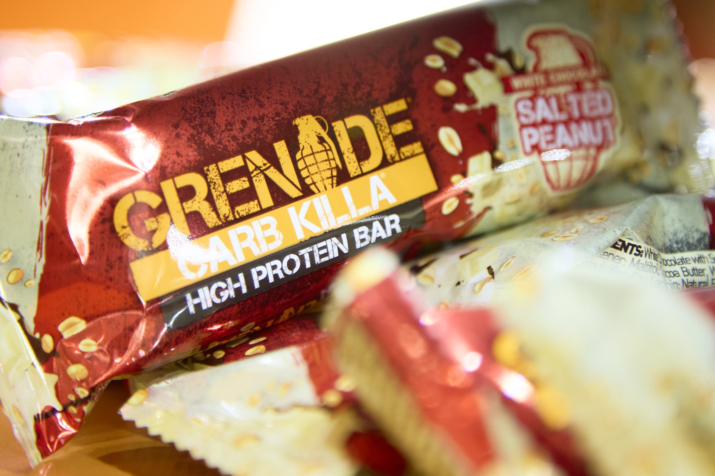 Close-up of a Redcon1 Care Killa high protein bar package with salted peanut flavor, showing part of the bar and colorful graphics.