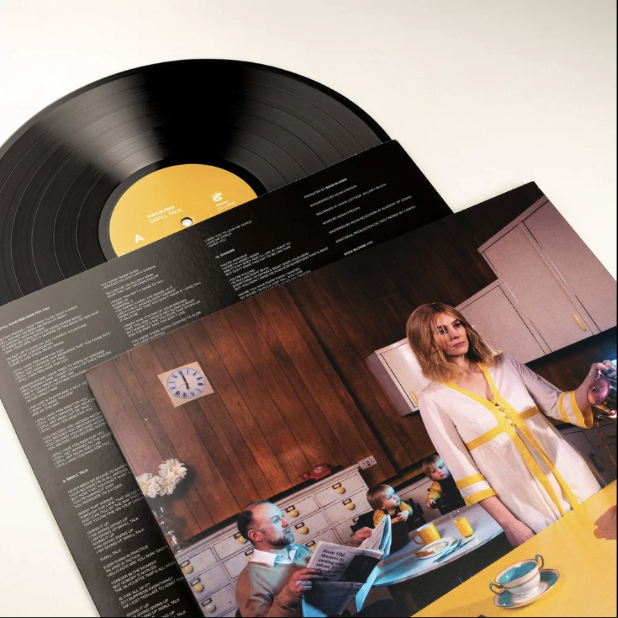A record cover showing a strong high quality professional lighted image of  a woman and children in a kitchen.