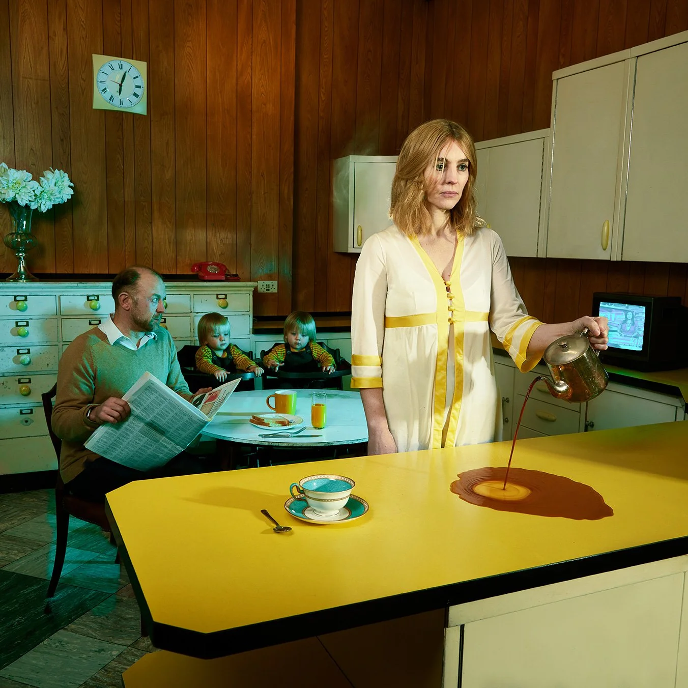 Captivating professional commercial photo of  woman pouring coffee onto a yellow kitchen counter, with a cup and spoon in the foreground. shooting in location with professional lighting setup. Record cover for music band.