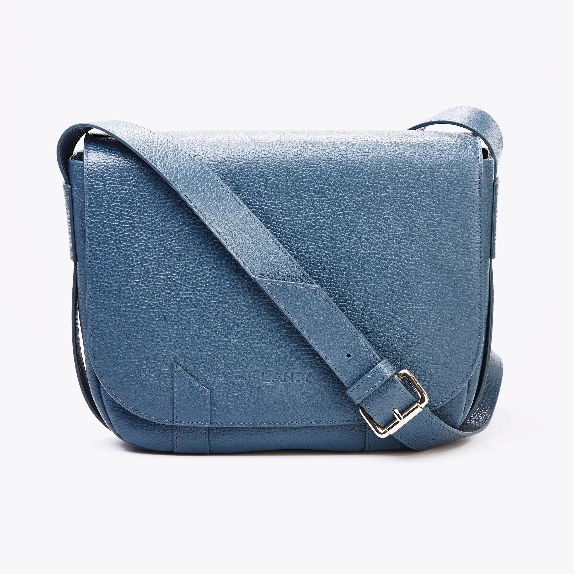 Advertising profession product photo taken in studio of a blue leather shoulder bag with adjustable strap and embossed 'LANDA' logo, isolated on white background.