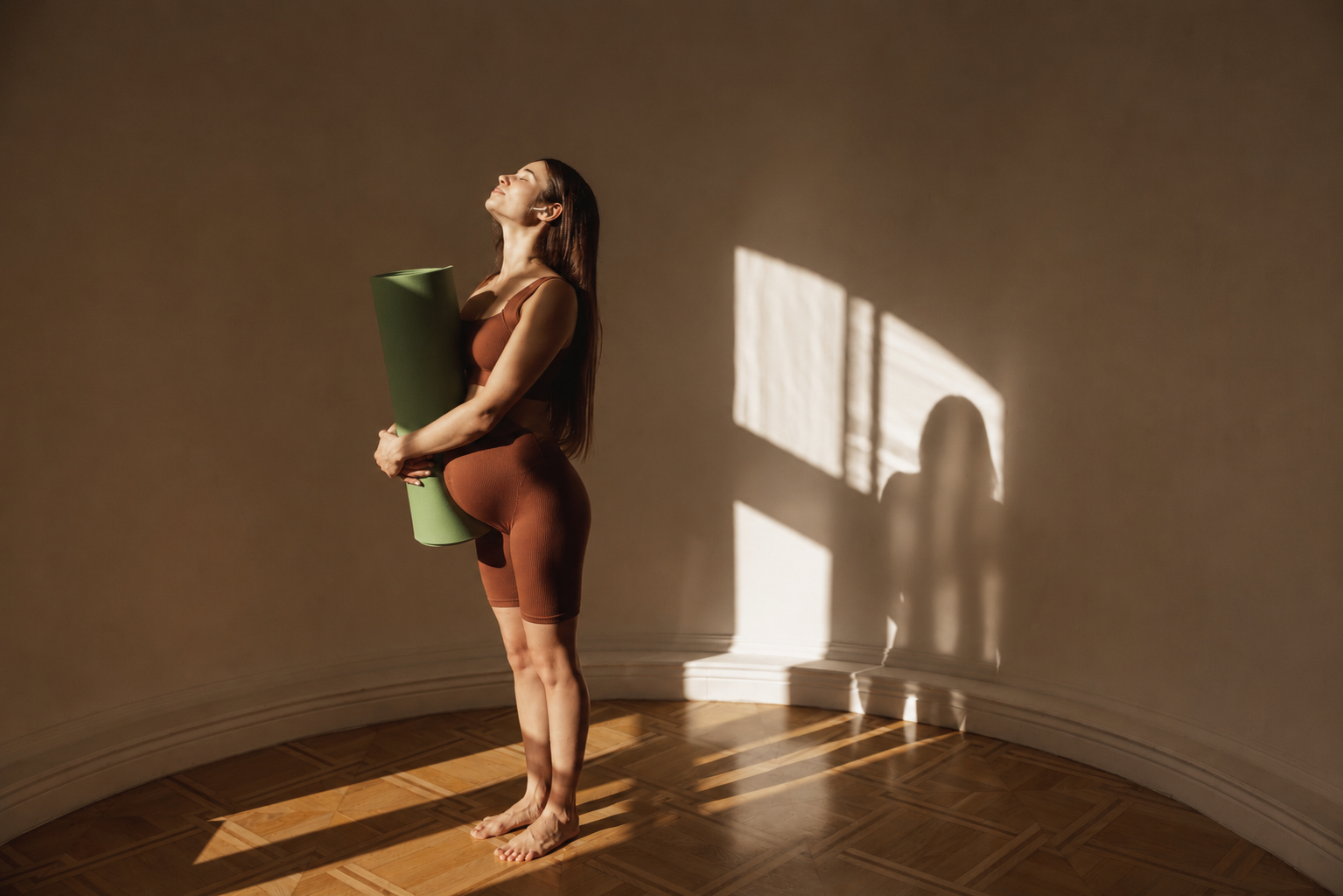 femme enceinte avec tapis de yoga au soleil du soir