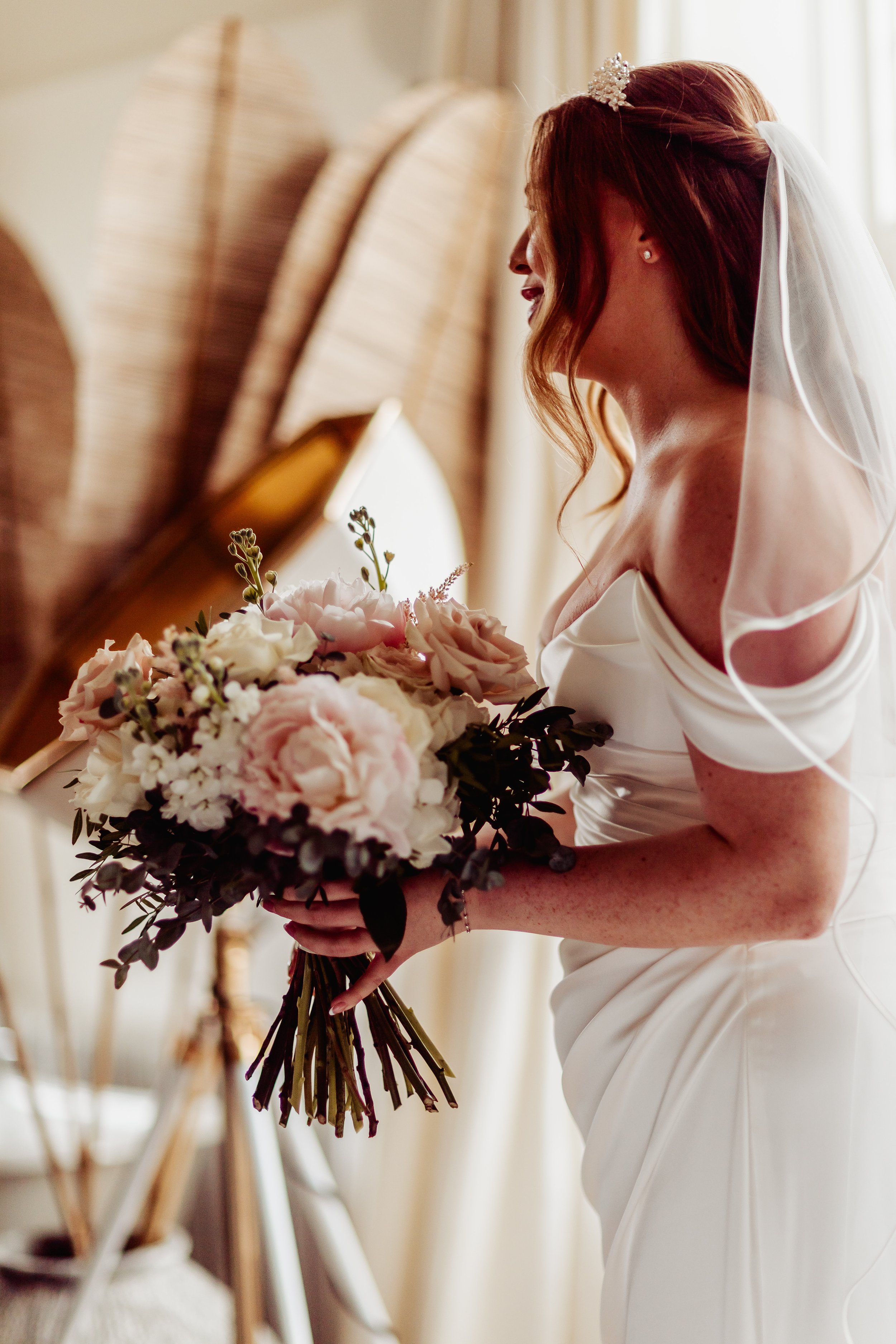 A bride with red hair holding a bouquet of pink and white flowers. East Yorkshire based wedding florals, handcrafted wedding flowers.